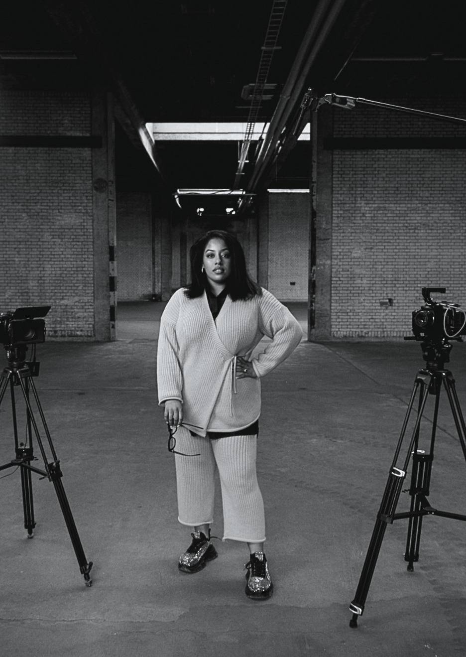 Saïda Fakher standing between two cameras on a set, in black and white.